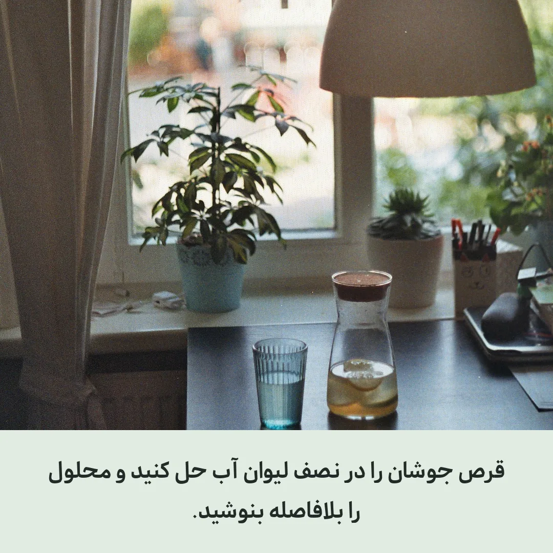 لیوان و پارچ آب روی میز کنار پنجره