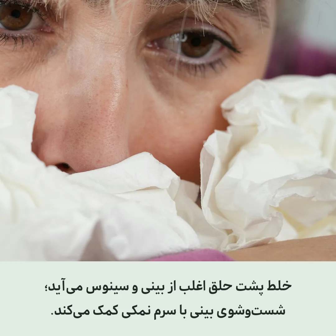 نمای نزدیک از فردی که بینی‌اش را با دستمال کاغذی گرفته است
