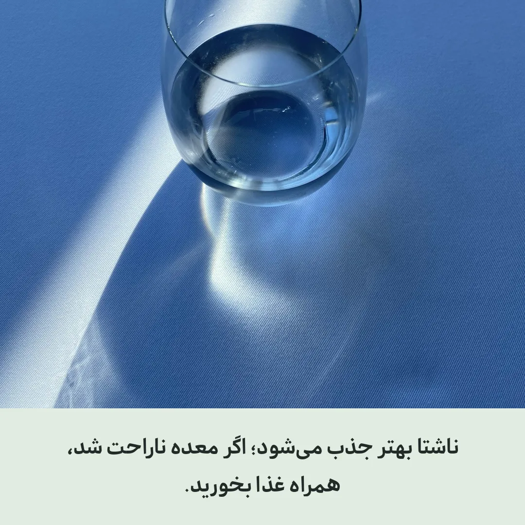لیوان آب روی میز کنار پنجره