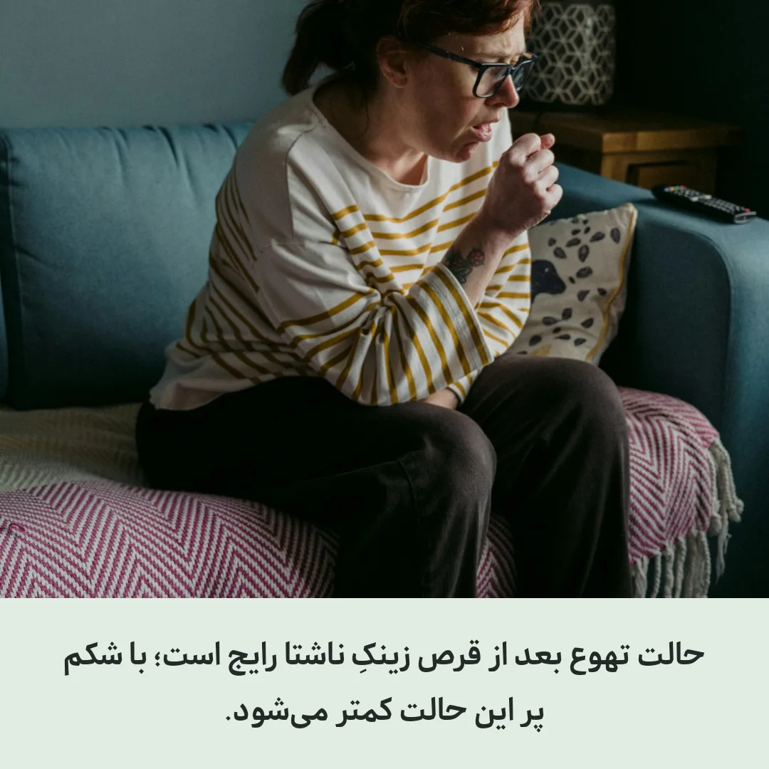 خانمی که روی مبل نشسته و دستش را روی شکم گذاشته