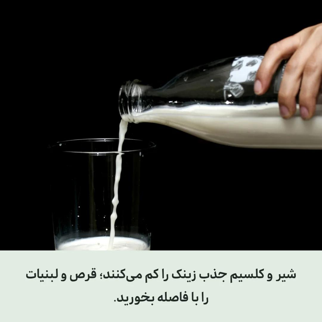 لیوان شیر کنار چند قرص روی میز چوبی